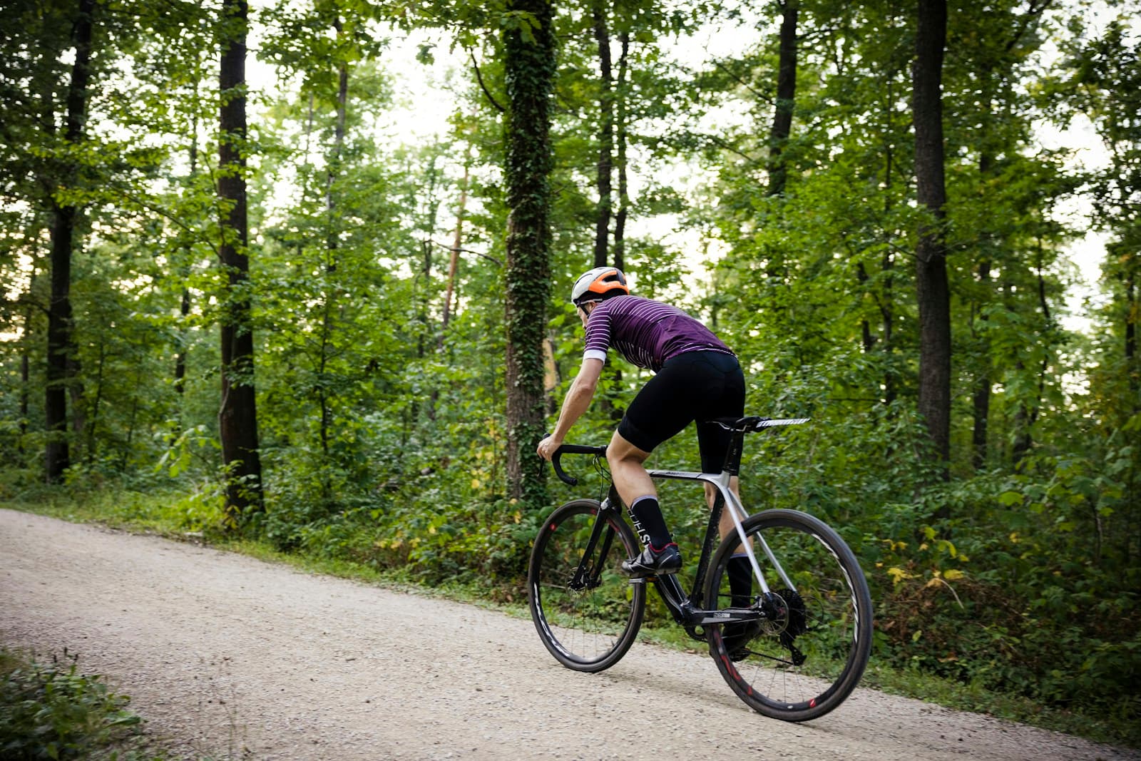Cyclist on a leaf-strewn woodland trail, relaxed pace